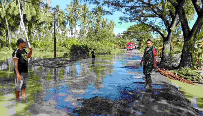 Jalan Poros Salonro Digenangi Banjir, Praka Hendra dan Warga Arahkan Kendaraan Lalui Jalur Rusak